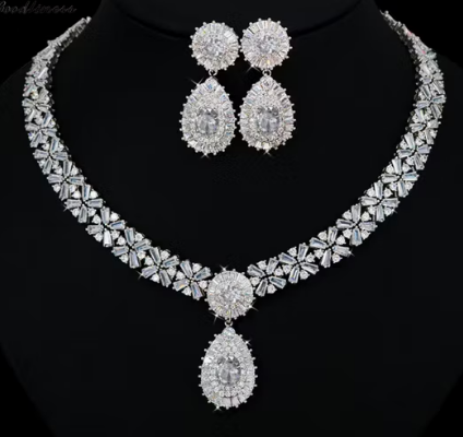 Silver necklace and earrings set on a black background